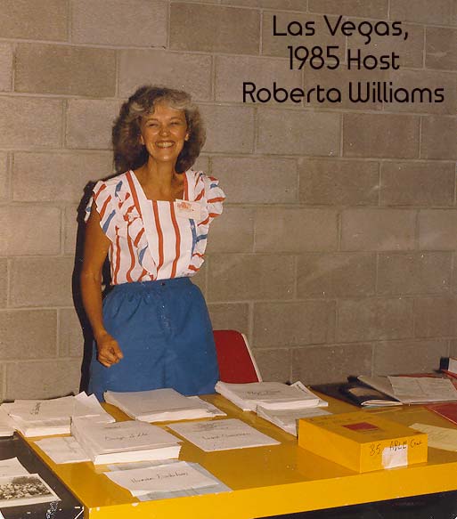 Photo of woman in 1980s attire smiling and standing behind table